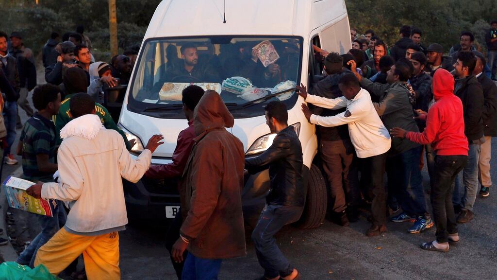 Migrants surround van as it arrives to distribute food at the makeshift camp called “The New Jungle” in Calais, France. Photograph: Regis Duvignau/Reuters.