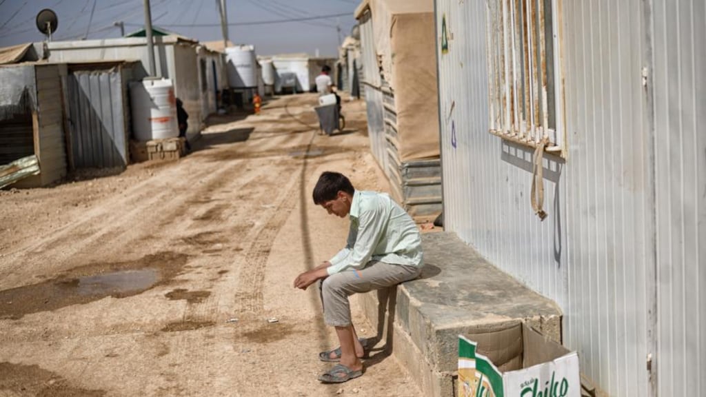 A young Syrian outside his trailer at the Zaatari refugee camp in Jordan. Refugees’ resignation and resilience combine with major infrastructure investments to make the place feel ever more like an entrenched city than a makeshift way station. Photograph: Samuel Aranda/The New York Times