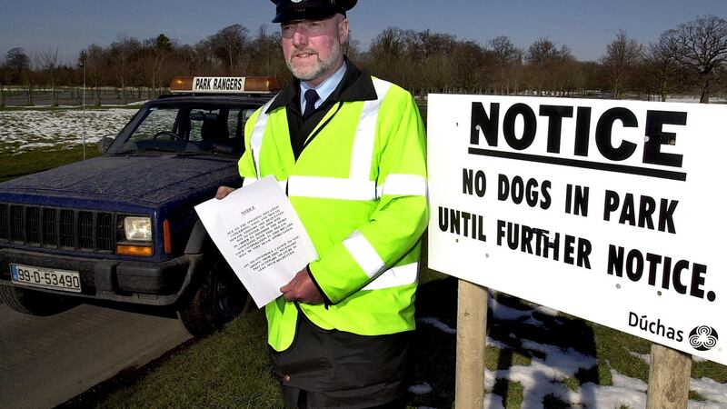 Park ranger Brendan Kinsella handing out a notice to people in the Phoenix Park asking them not to enter the park in order to minimise the risk of spreading foot-and-mouth disease to the deer in the park in March 2001.