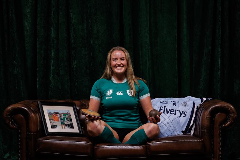Fiona Tuite holds her discus and shot putt along with a photograph of her in Ireland kit at the World Athletics Championships and her Dublin jersey from the All-Ireland 2013 Minor Final. Photograph: Ben Brady/Inpho