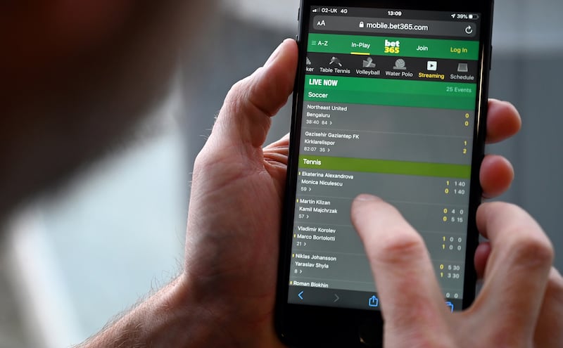 A punter visits an online betting site on his mobile phone. Photograph: Paul Ellis/AFP via Getty Images)