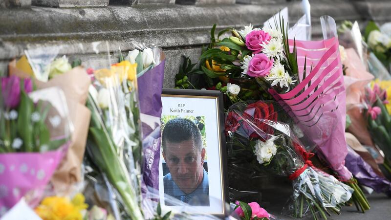 A picture of British policeman Keith Palmer is seen among flowers near the Houses of Parliament in central London. Photograph  Facundo Arrizabalaga/EPA