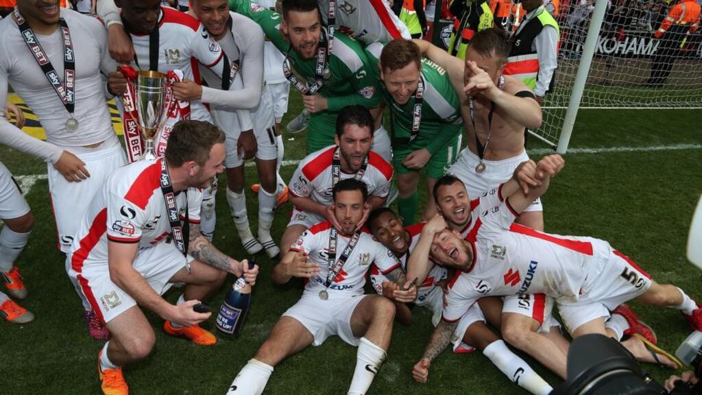 MK Dons players celebrate after gaining promotion to the Championship at the end of the League One match against Yeovil Town at Stadium mk. Photo: Pete Norton/Getty Images