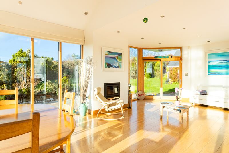 Extensively glazed living area with stove and two doors out to garden