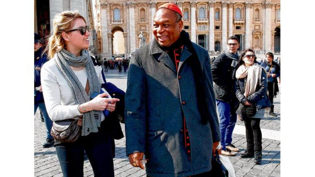 Cardinal John Olorunfemi Onaiyekan of Nigeria talks to a tourist in St Peter's Square in Rome yesterday. Preparations for electing a new pope began in earnest yesterday as the college of cardinals opened daily talks. photograph: reuters