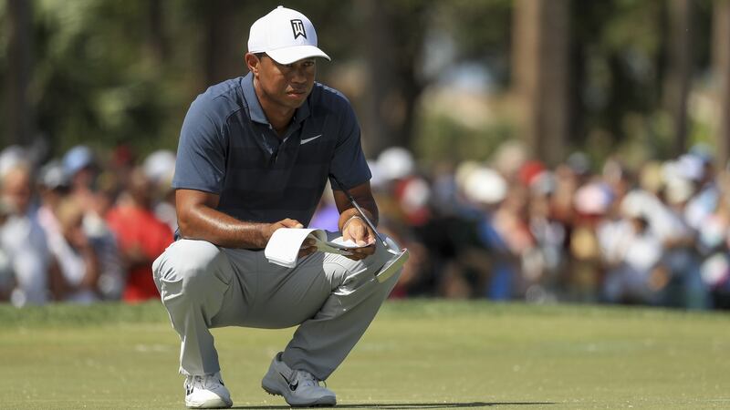 Woods reads a putt on the third green on the way to a round of 69. Photo: Mike Ehrmann/Getty Images