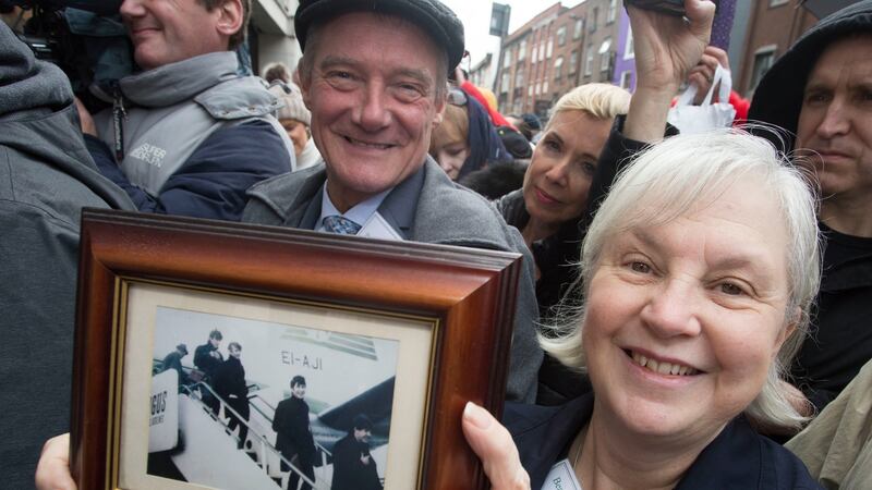 Members of Beatles Ireland, Pete Brennan and Pat Moore, hold up a picture of the Beatles arriving into Dublin for their concerts. Photograph: Colm Mahady /Fennells