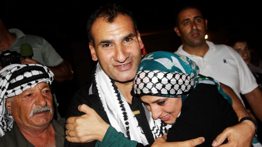 Freed Palestinian prisoner Hosni Sawalha (C) is greeted by his sister upon arrival in the West Bank village of Azmout this morning. Israel freed 26 Palestinian prisoners  to keep US-sponsored peacemaking on course. Photograph: Abed Omar Qusini/Reuters.