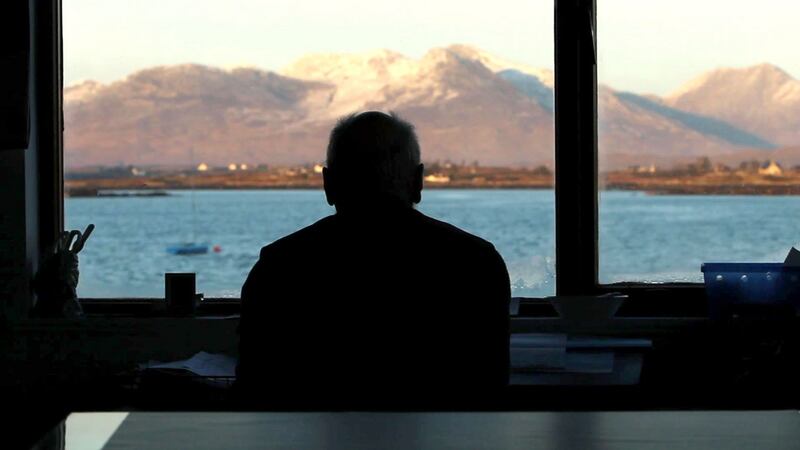 Tim Robinson in silhouette looks out over Connemara