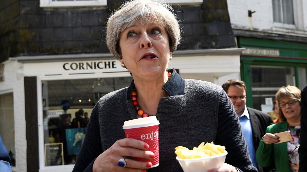 British prime minister Theresa May has some chips and a drink while on a walkabout during a election campaign stop in Mevagissey, Cornwall. Photograph: Dylan Martinez/PA Wire