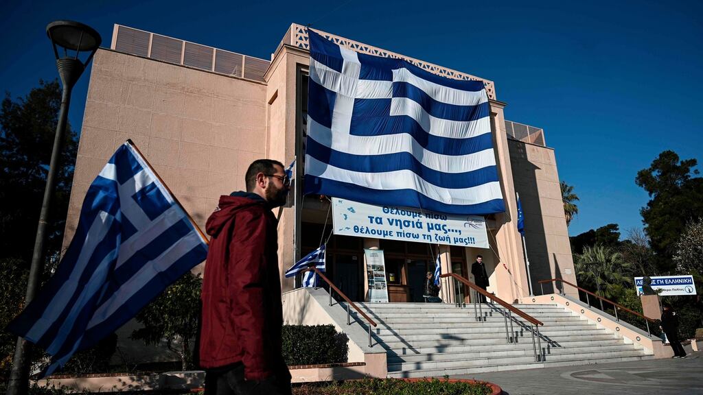 A man walks past a big national Greek flag hanging on the facade of the municipal theatre of Mytilene in the island of Lesbos on January 22nd, 2020. Photograph: Aris Messinis/AFP via Getty Images