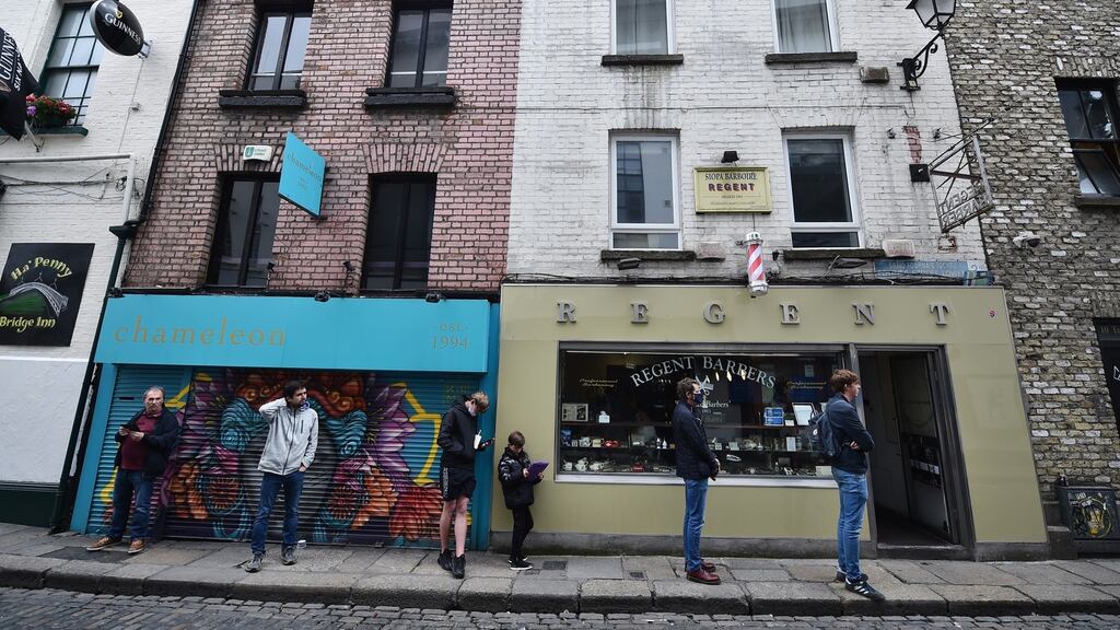 Customers waiting in line outside the Regent Barbers shop in Dublin on Monday. Photograph:  Charles McQuillan/Getty