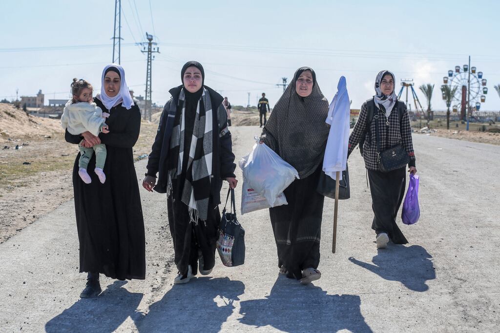 Displaced Palestinian women carry a white flag and belongings as they flee the Hamad City area in Khan Yunis in the southern Gaza Strip on Tuesday. Photograph: AFP via Getty Images