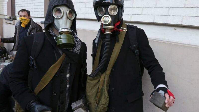 Masked protesters hold stones during clashes with police in Kiev February 18, 2014. Anti-government protesters clashed violently with police in central Kiev on Tuesday, a day after Moscow moved to cement its influence over Ukraine with $2 billion in cash to shore up the former Soviet state's heavily indebted economy. A parliamentary deputy said on Facebook that three demonstrators had been killed, and Ukrainian television said five protesters had been hurt in the clashes. Neither report could immediately be confirmed. REUTERS/Konstantin Chernichkin (UKRAINE - Tags: POLITICS CIVIL UNREST)