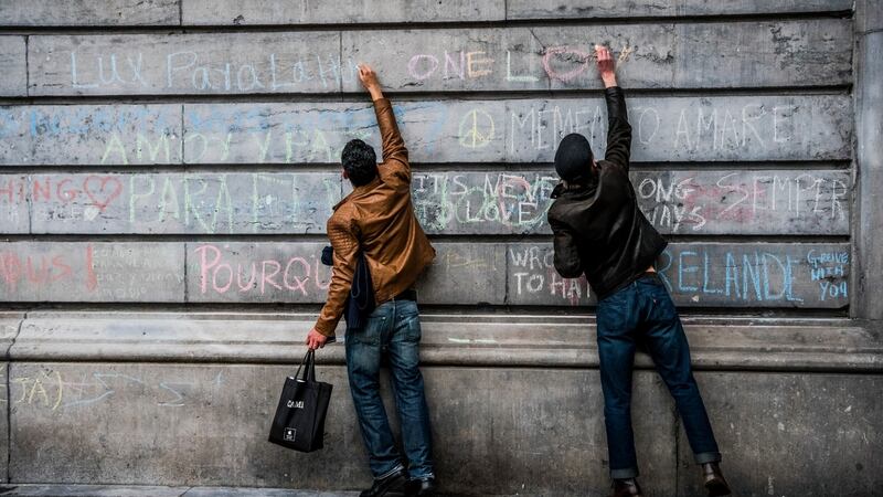 Boys write tributes in chalk to the victims of the attacks across Brussels near Place de la Bourse in Brussels. Photograph: Daniel Berehulak/The New York Times