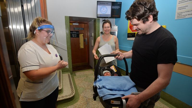 National Maternity Hospital staff midwife  Tara Finn hands over their two-day-old son  Eli to father Sam and mother Sorcha Hartigan as they leave Holles Street in Dublin. Photograph: Alan Betson