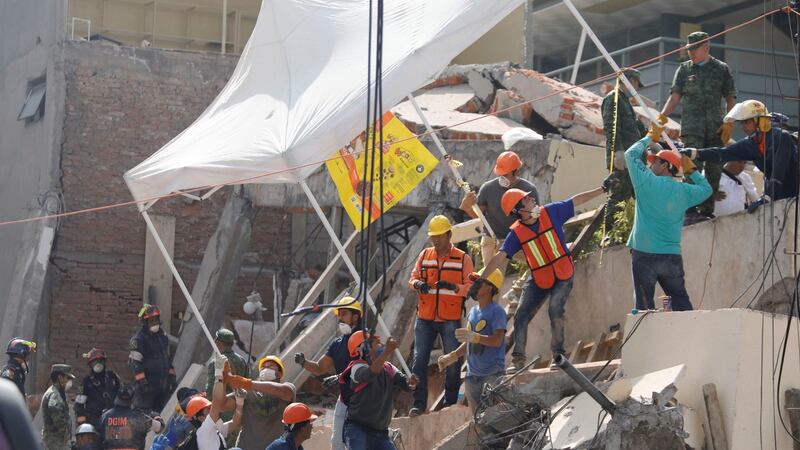 Rescue workers transport a tent as they search for students through the rubble at Enrique Rebsamen school after an earthquake in Mexico City. Photograph: Reuters/Edgard Garrido