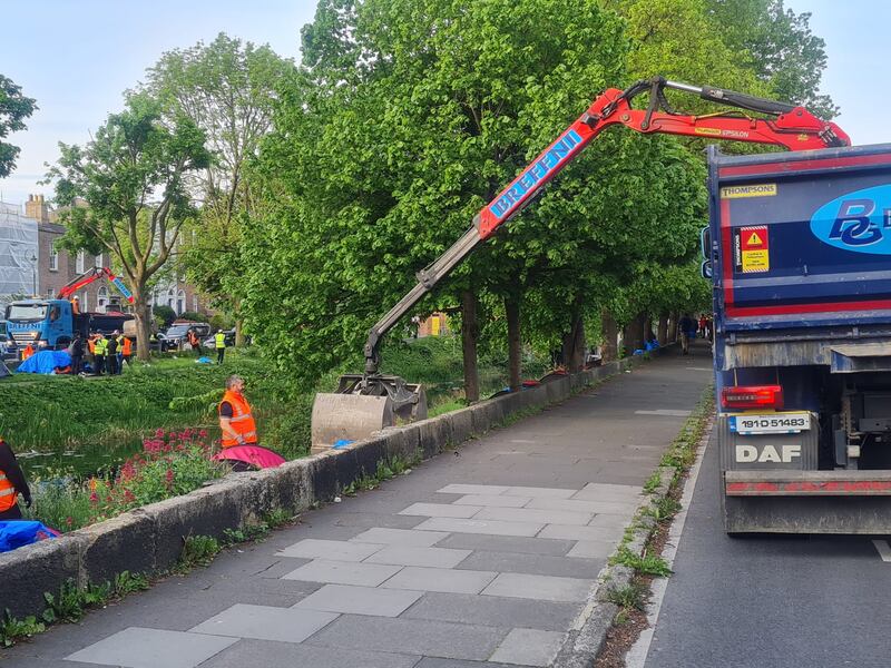 A truck with a claw lifting tents along the Grand Canal shortly after International Protection applicants staying there were told they were being moved on. Photograph: Kitty Holland