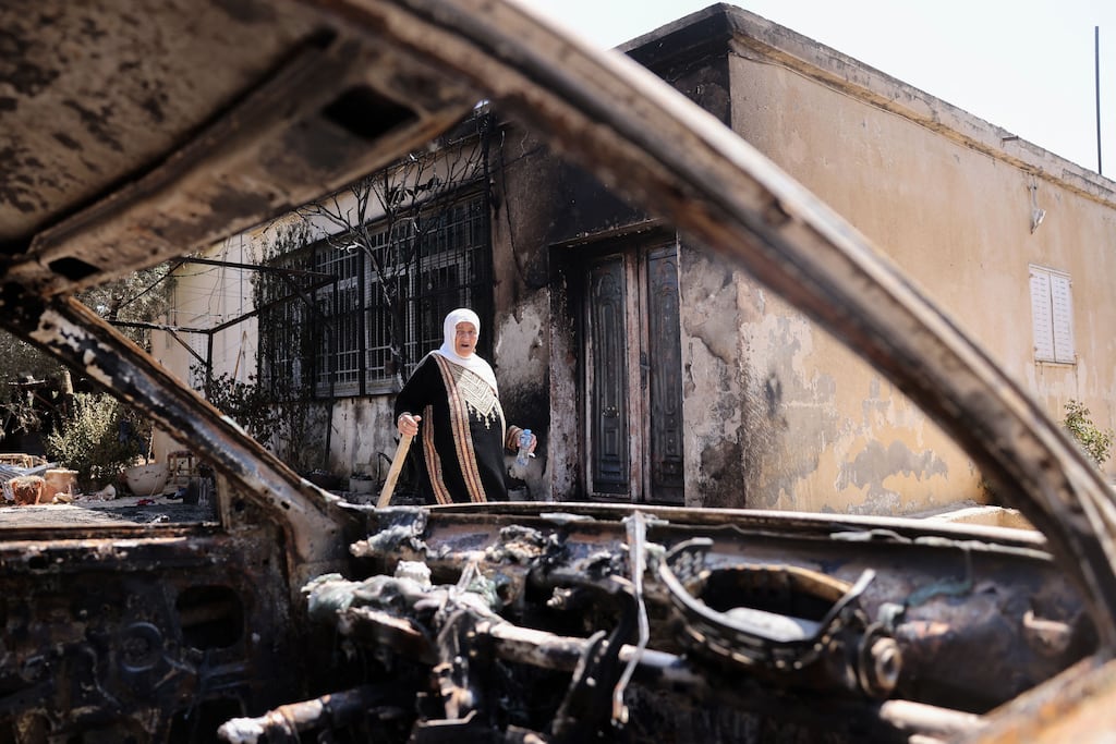 A Palestinian woman outside her house  in Turmus Aya near the occupied West Bank city of Ramallah. Her home was set on fire by Israeli settlers. Photograph: Ahmad Gharabli/AFP via Getty Images