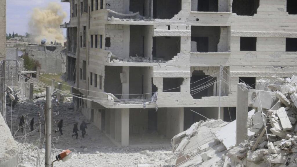 Free Syrian Army fighters run for cover amid the rubble of collapsed buildings from shelling by forces loyal to Syria’s president Bashar Al-Assad on Zabdin village, a suburb of Damascus on Sunday. The son of a British local politician has been deported from Turkey two weeks after he was detained with eight other Britons trying to cross illegally into Syria, the state-run Anatolian news agency reported on Tuesday. Photograph: Reuters