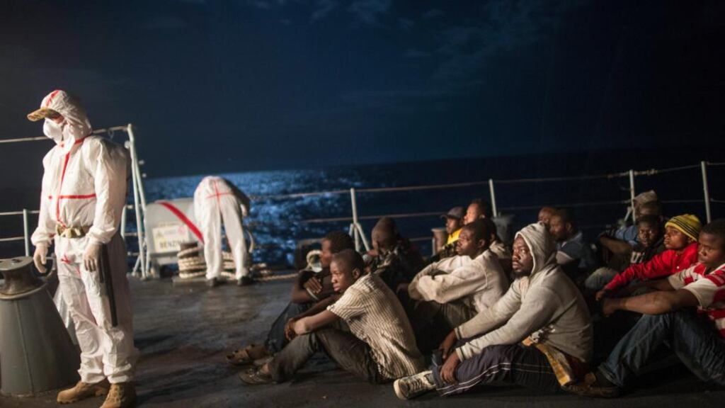 Italian marines prepare to check and document African migrants after transporting them from a commercial ship to a navy vessel in the Mediterranean Sea between Italy and Libya early in October 2014. Photograph: Lynsey Addario/The New York Times)