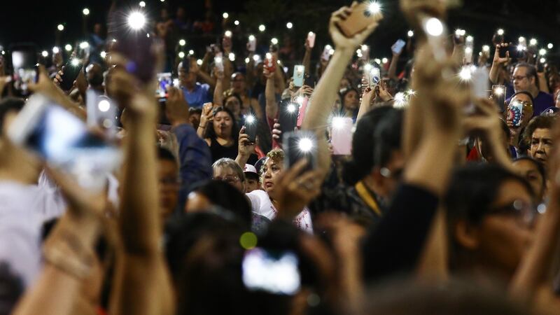 People hold up their phones in lieu of candles at an interfaith vigil for victims of a mass shooting, which left at least 20 people dead, on August 4th, 2019 in El Paso, Texas. Photograph: Mario Tama/Getty Images