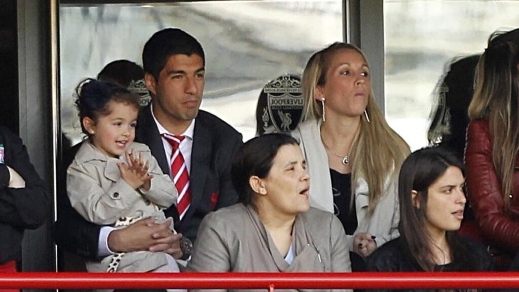 Liverpool’s Luis Suarez watches the Merseyside derby from the stands with his wife and daughter at Anfield. Photograph: Peter Byrne/PA Wire
