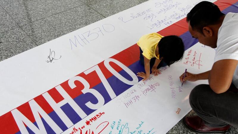 People write well wishes for the passengers of the missing Malaysia Airlines flight MH370 at a viewing gallery at Kuala Lumpur International Airport today. Photograph: Reuters