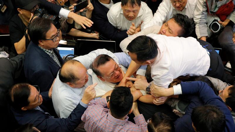 Pro-democracy and pro-Beijing lawmakers scuffle in the chamber at legislative council in Hong Kong on Saturday. Photograph: Kin Cheung/AP