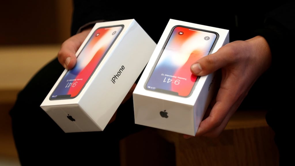 A man holds two boxes for Apple’s new iPhone X at an Apple Store. Apple said it pays tax at Ireland’s statutory 12.5 per cent. Photograph: Reuters