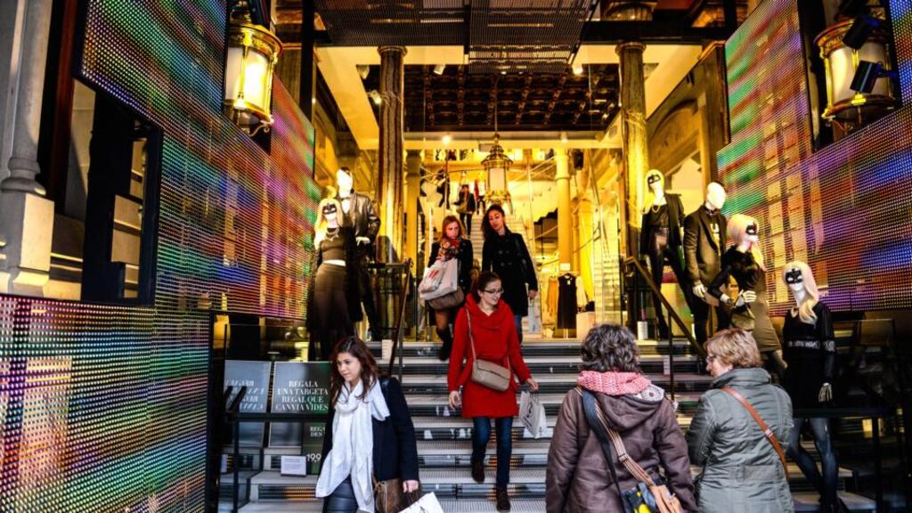 Customers exit and enter a H&M fashion store in Barcelona, Spain. Photographer: David Ramos/Bloomberg