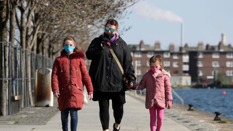 Liz Connor and her daughters Ellen (8) and Grace (6) wear protective facemasks as they go for a walk on Mother’s Day in Dublin. Photograph: Brian Lawless/PA Wire