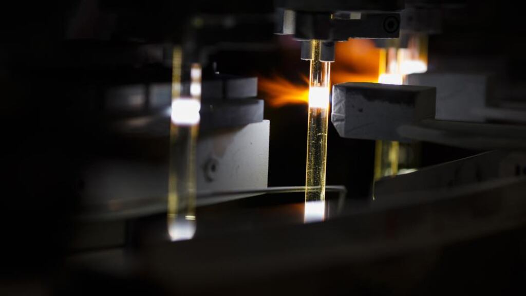 Glass halogen light tubes are heated before cutting at the Royal Philips   automotive lighting factory in Aachen, Germany. Photographer: Jasper Juinen/Bloomberg