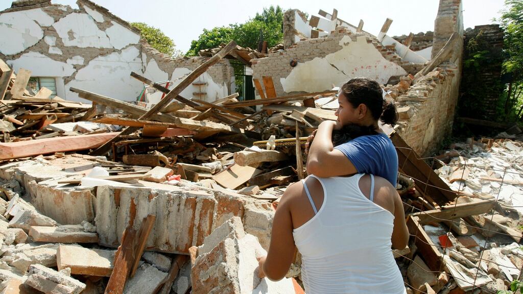 Women hug while standing next to a destroyed house after an earthquake struck the southern coast of Mexico. Photograph: Jorge Luis Plata/Reuters