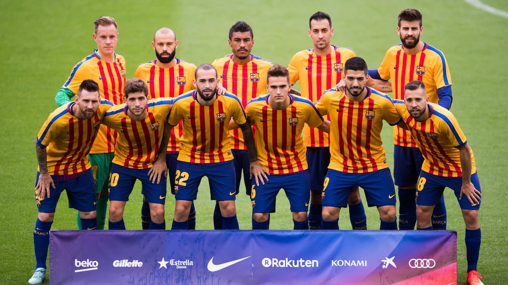 The Barcelona team pose for a team photo wearing shirts in the colours of the Catalan flag, the club earlier condemned the actions of Spanish police in the city on Sunday. Photograph: Getty Images