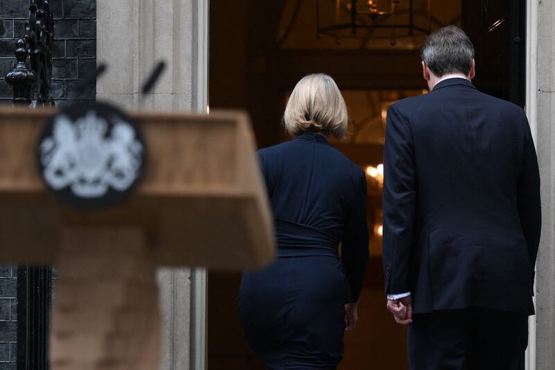 Britain's prime Minister Liz Truss (L) and her husband Hugh O'Leary walking back inside 10 Downing Street, in central London following Ms Truss's resignation statement. Photograph: Daniel LEAL / AFP/Getty
