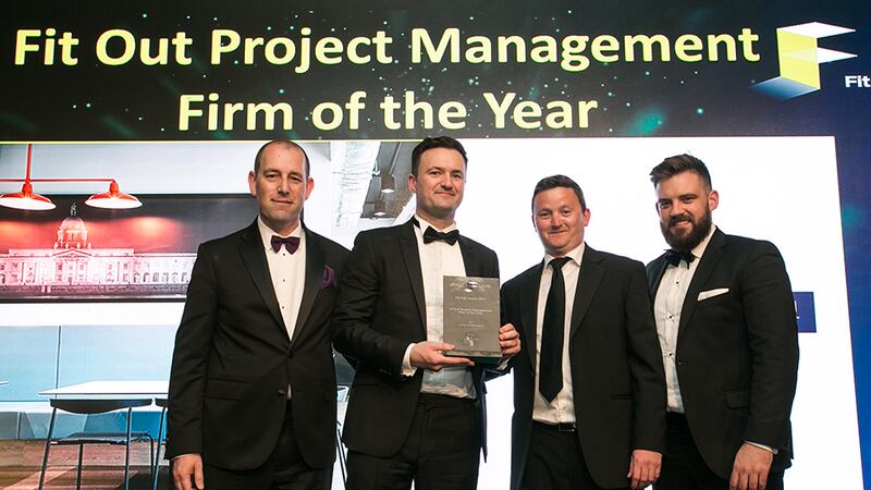 Trevor Schwer, MD, The Interiors Group, presents the Fit Out Management Firm of the Year award to the Turner & Townsend team
