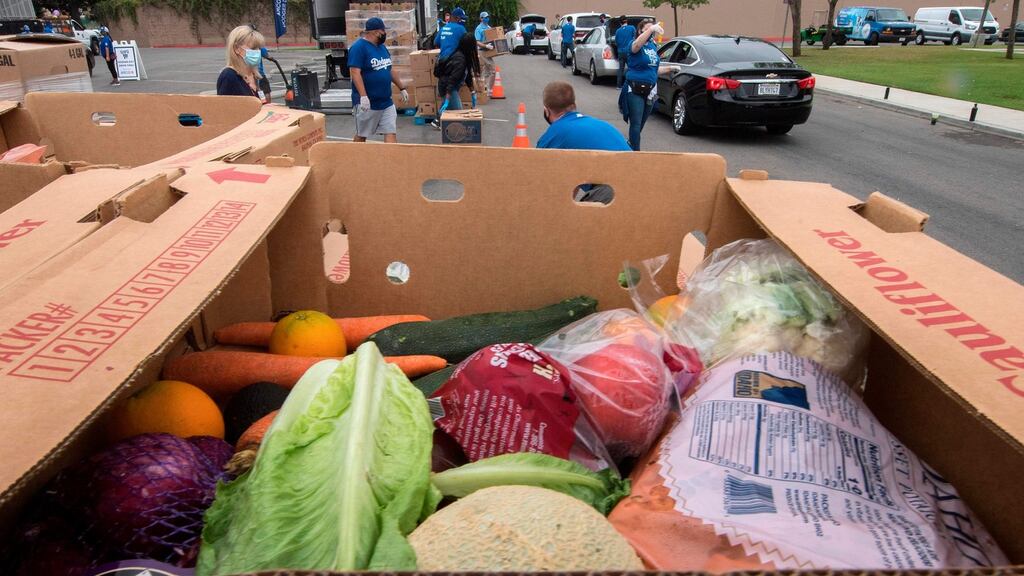 Staff and volunteers with The Los Angeles Dodgers Foundation, distribute food and other goods for people facing economic hardship in Huntington Park, California. Photograph: AFP via Getty
