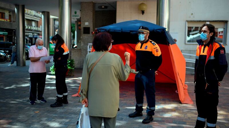 Civil Defence members inform residents on the new restrictions imposed in the neighbourhood under partial lockdown of Usera, in Madrid, on Monday. Photograph: Oscar Del Pozo/AFP via Getty Images