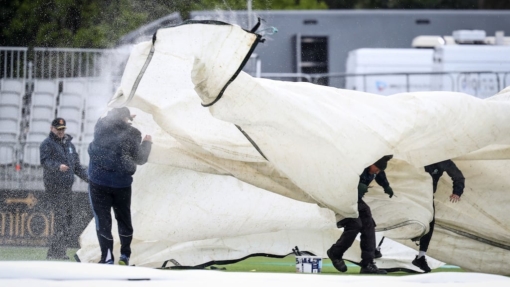 Groundstaff struggle with the covers on the first morning of the Test match between Ireland and Pakistan at Malahide. Photograph: Oisín Keniry/Inpho