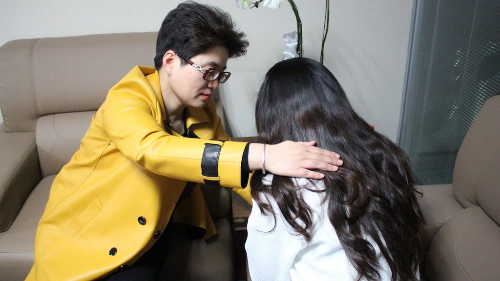 Ming Li, a consultant at the Weiqing mistress hunters agency, comforts one of her clients.