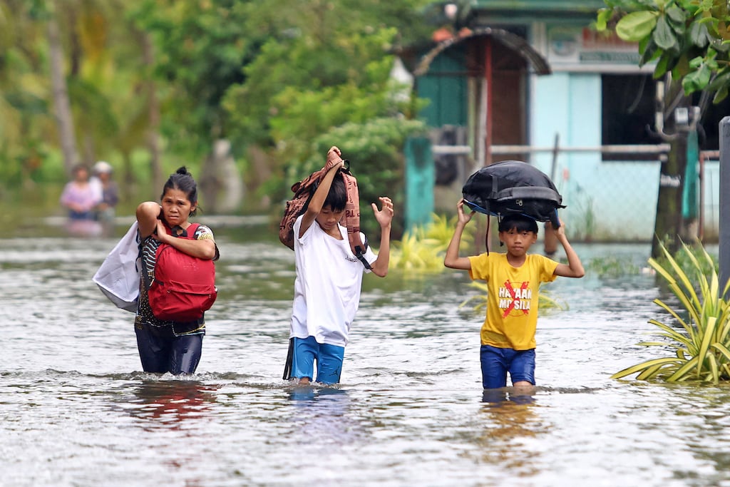 Residents evacuate flooded homes in the Philippines, where Typhoon Kalmaegi killed more than 200 people last week. Photograph: Erwin Mascarinas/AFP Getty