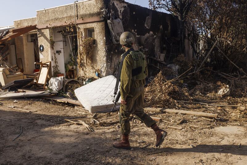 An Israeli soldier walks past homes in Kibbutz Kfar Aza which were destroyed during fighting following the attack on Israel by Hamas militants on October 7th. Photographer: Kobi Wolf/Bloomberg