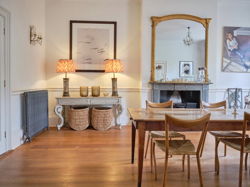 Diningroom: Chairs from the Conran shop, 'sadly now impossible to find'; oil painting of the couple's children by Emma Foale, an artist they first read about in The Irish Times; baskets under console table from Dunnes.