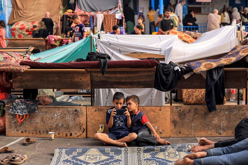 Playing games on a phone in a shelter for displaced Palestinians in Khan Yunis. Photograph: Mahmud Hams/AFP via Getty Images