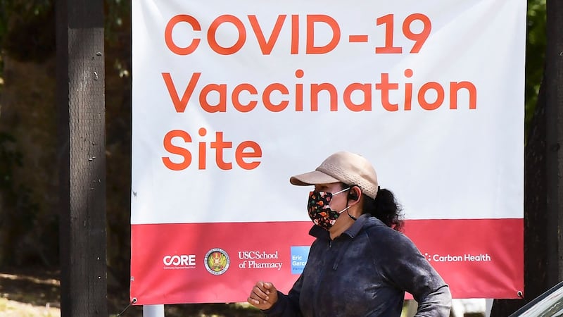 A woman walks past a Covid-19 vaccine site in Los Angeles, California. Photograph: Frederic J Brown/AFP via Getty Images