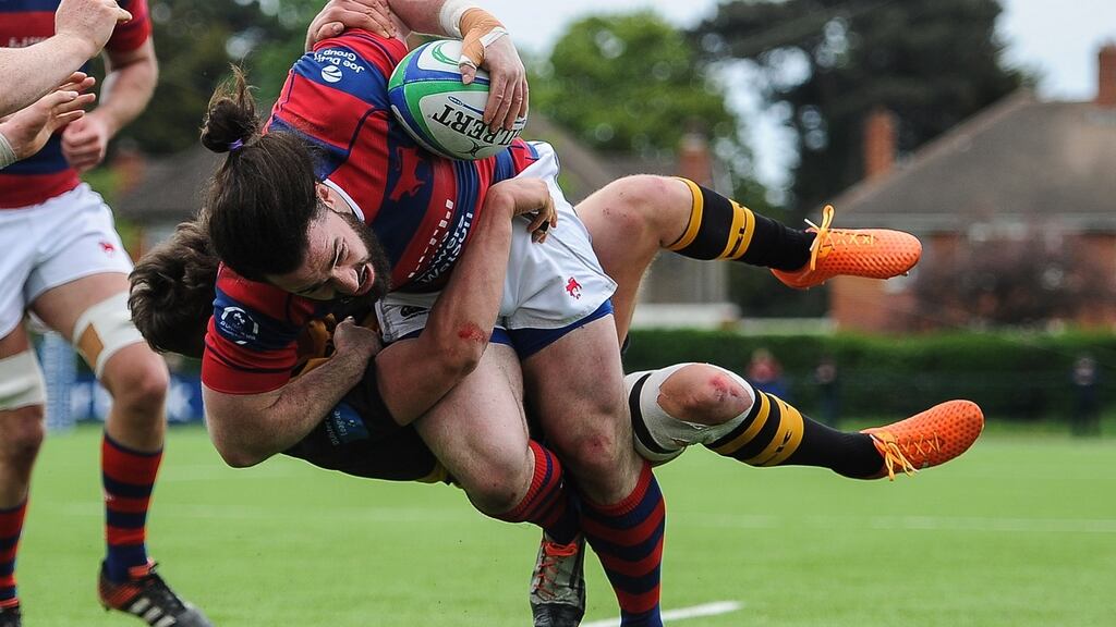 Clontarf’s Mick McGrath is tackled by James O’Connor of Young Munster in Sunday’s Ulster Bank League Division 1A semi-final. Photograph: Tommy Grealy/Inpho