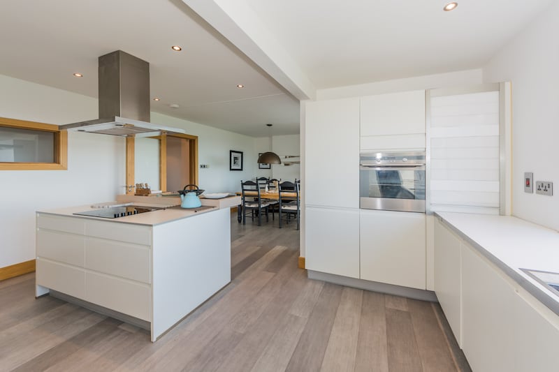 The kitchen/living/diningroom area has a wood-burning stove, and a telescope ranged close to the windows.