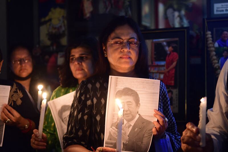 Members of the Japanese information and study centre in India hold a candlelight vigil to pay tribute to the late former prime minister. Photograph: Sam Panthaky/AFP/Getty