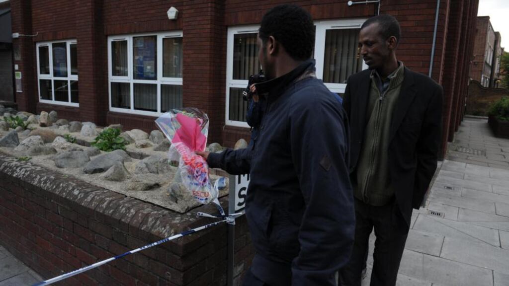 Men lay a floral tribute close to the scene where a man was murdered in Woolwich. Photograph: Nick Ansell/PA Wire
